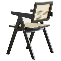 Sillón Jeanneret Negro con estructura de madera y respaldo de mimbre.