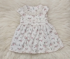 Vestido infantil Branco com estampa de flores em tons de rosa e detalhe em babado no decote.