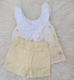 Conjunto Anjos com blusa branca de babados e short amarelo, decorado com borboletas coloridas.