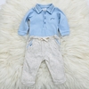 Conjunto babycomposto por um body azul com colarinho e calças claras com detalhes em azul.