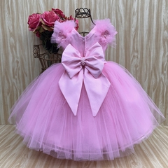 Vestido de festa infantil na cor rosa, com saia de tule e laço grande na cintura.