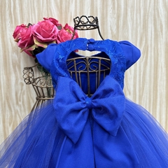 Vestido de festa infantil Estefani na cor azul, com detalhes em tule e laço grande nas costas.