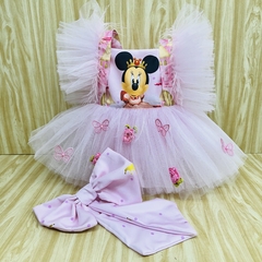 Macacão rosa da Minnie com tule e laço, decorado com borboletas e flores.