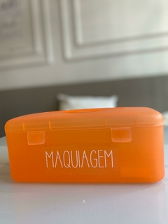 Necessaire Frasqueirinha Laranja com etiqueta de Maquiagem em cima da mesa.