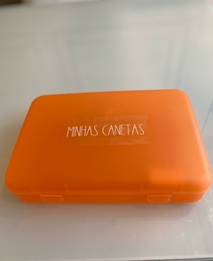 Big Case Laranja com etiqueta personalizada de Canetas em uma mesa.