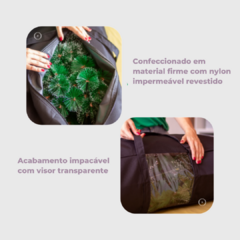 Imagem da bolsa organizadora para árvore de Natal na cor preta, mostrando seu interior com galhos verdes e detalhes do material impermeável e visor transparente.