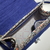 a imagem mostra o interior de uma bolsa tiracolo com alça de mão azul pequena