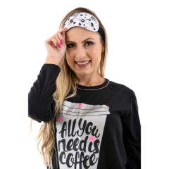 A parte de cima do pijama é preta, de manga longa e tem um decote redondo.
Há um texto na frente da parte superior que diz “All You Need is Coffee” ("tudo o que você precisa é de café"), cercado por elementos decorativos.
As calças do pijama são brancas e