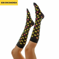 A meia 3/4 na imagem é preta com estampas coloridas de fantasminhas do Pac Man em diferentes poses e expressões. Os fantasmas nas meias têm cores variadas, incluindo amarelo, verde, vermelho e laranja. Cada fantasma do Pac Man tem um design simples e esti