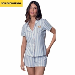 pijama americano listrado em tons de azul claro e branco. O pijama é composto por uma camisa de botão frontal de mangas curtas e shorts que combinam com a camisa. A camisa tem um bolso no lado esquerdo do peito, que contém uma ilustração encantadora de um