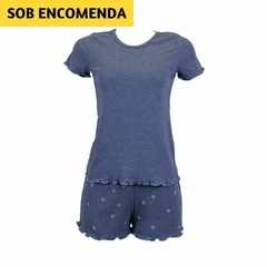 O shortdoll é composto por um top de manga curta e shorts.
O top é de cor azul escuro sólida, com mangas curtas e uma textura visível. Os shorts são da mesma cor azul escuro, mas adornados com um padrão de corações mais claros. Ambas as peças têm bainhas 