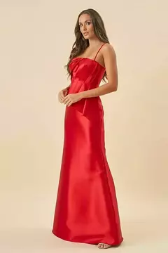 Vestido de festa vermelho disponível para locação, com alças finas e caimento elegante, exibido por uma modelo em pé.