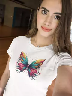 Modelo usando uma camisa branca com estampa de borboletas coloridas.