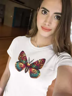 Modelo usando uma camisa branca BabyLook com estampa de borboleta colorida.