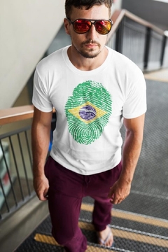 Homem usando uma camisa branca com estampa de digital verde e azul, representando a bandeira do Brasil.