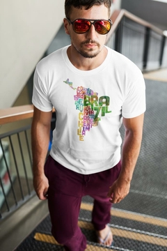 Homem usando uma camisa branca com o mapa do Brasil feito de palavras relacionadas a países da América do Sul.