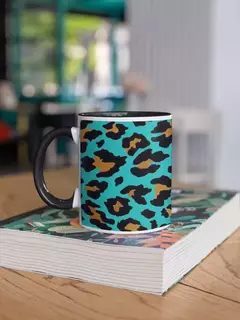 Caneca de porcelana com estampa de animal print em fundo azul e detalhes em dourado, apoiada sobre uma mesa de madeira.