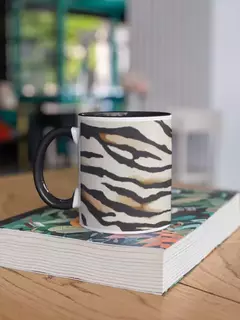 Caneca de porcelana com estampa de zebra, sobre uma mesa de madeira.