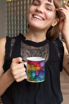 Mulher sorrindo segurando uma caneca com design de bolas coloridas e abstratas.