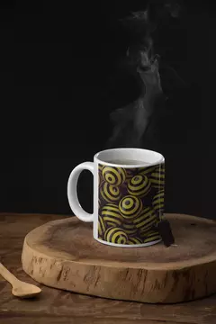 Caneca branca com design de bolas abstratas amarelas e pretas, fumegante, em uma tábua de madeira.