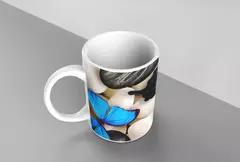 Caneca branca decorada com borboletas azuis e pedras em fundo neutro.