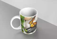 Caneca branca decorada com borboleta amarela e elementos naturais como folhas e pedras.