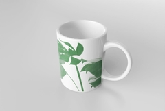 Caneca branca com estampa de folhagens verdes, ideal para bebidas quentes.