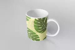 Caneca branca com estampa de folhagens verdes em fundo amarelo