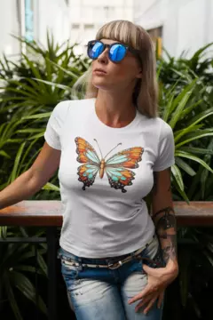 Modelo usando uma camisa branca com estampa de borboleta, cercada por plantas verdes.