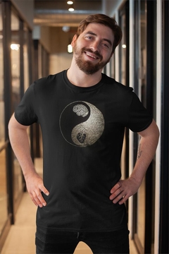 Homem sorridente usando uma camisa preta com estampa de Yin e Yang.