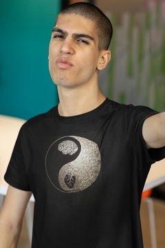 Modelo vestindo uma camiseta preta com estampa Yin e Yang, destacando um cérebro e um coração.